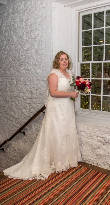Wedding Dresses with Beaded Floral Wreath on the Bodice and High Low Hem and Belt for a Delicate and Dramatic LookDavid's Bridal 7T3299 Wedding Dresses with Beaded Floral Wreath on the Bodice and High Low Hem and Belt for a Delicate and Dramatic LookDavid's Bridal 7T3299